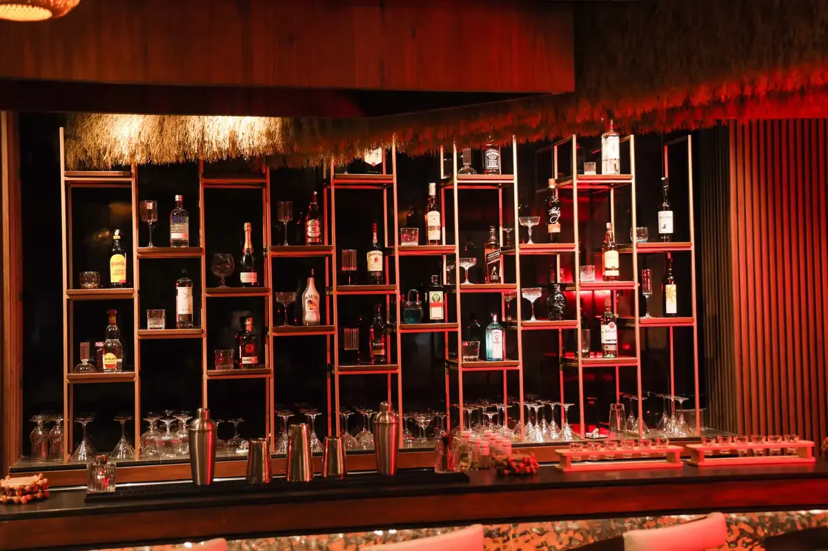 Backlit liquor shelving and premium glassware setup at Breeze Point rooftop restobar